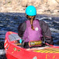 Jodi whitewater canoeing with a purple waist throw bag. 